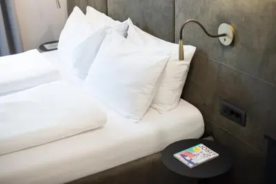 a hotel room with two beds with white pillows at Alte Schmiede Apartments & Rooms in Bolzano