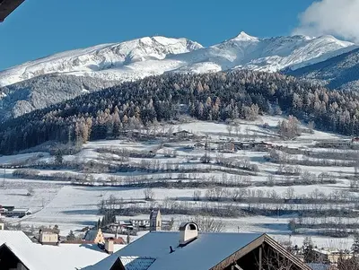 a snow covered mountain with a town in front of it at Appartement Margarethen in Vipiteno