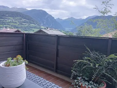 a balcony with a black fence and some plants at Appartement Margarethen in Vipiteno