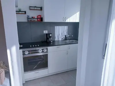 a white kitchen with a stove and a sink at Appartement Margarethen in Vipiteno