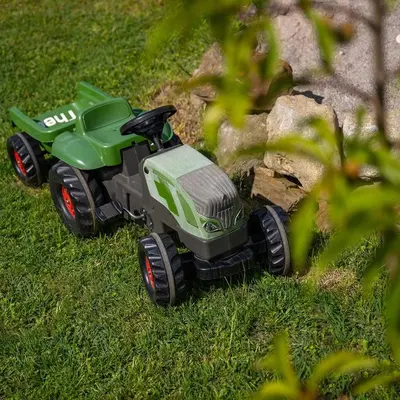 a green toy tractor in the grass at Biohof Gala in Naturno
