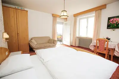 a bedroom with a bed and a couch and a table at Pföstlhof in Parcines