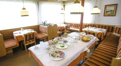 a dining room with a table with plates of food at Pföstlhof in Parcines