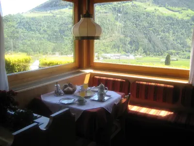 a table in a room with a large window at Pföstlhof in Parcines