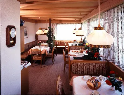 a dining room with tables and chairs and a clock at Pföstlhof in Parcines
