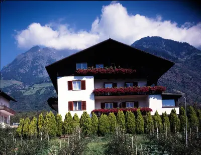 a building with flowers on the side of it at Pföstlhof in Parcines