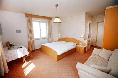 a bedroom with a large bed and a couch at Pföstlhof in Parcines