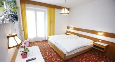a hotel room with a bed and a table and a window at Pföstlhof in Parcines