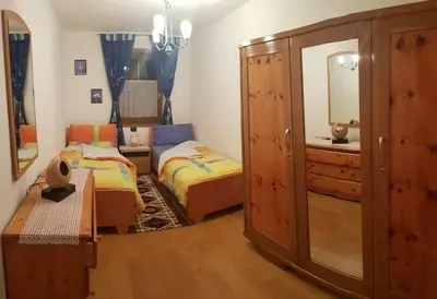 a bedroom with two beds and a dresser and a mirror at Casa Alessio in Sicina