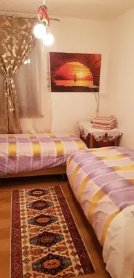 two beds in a room with a rug at Casa Alessio in Sicina