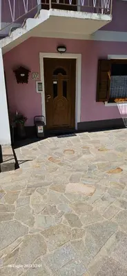 a house with a brown door and a stone floor at Casa Alessio in Sicina
