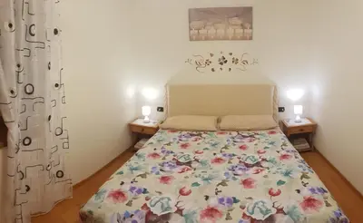 a bedroom with a bed with a floral bedspread at Casa Alessio in Sicina