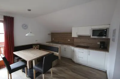 a kitchen with a wooden table and a table and chairs at Haus Trögl in Tires