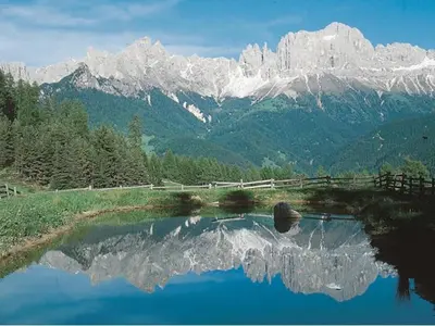 a reflection of a mountain in a pool of water at Haus Trögl in Tires