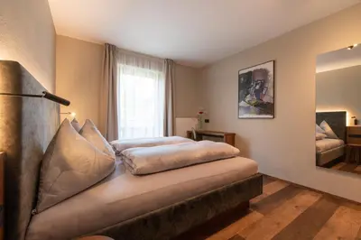 a bedroom with a bed and a window at Apartments Karbon in Castelrotto