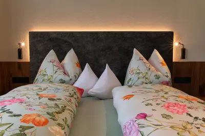 a group of pillows sitting on top of a bed at Apartments Karbon in Castelrotto