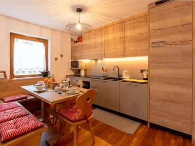 a kitchen with a table and a dining room at Apartment Ca' di nonón by Interhome in Penia
