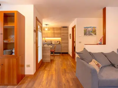 a living room with a couch and a kitchen at Apartment Ca' di nonón by Interhome in Penia