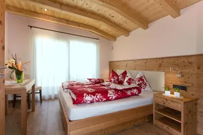 a bedroom with a large bed with a window at Apartments Cornelia in Castelrotto