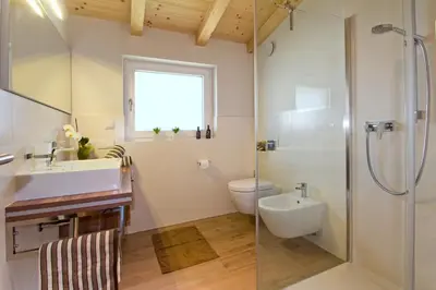 a kitchen and living room with a table and a couch at Apartments Cornelia in Castelrotto