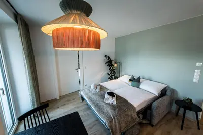 a bedroom with a bed and a large lamp at ANDERS City Loft in Brunico