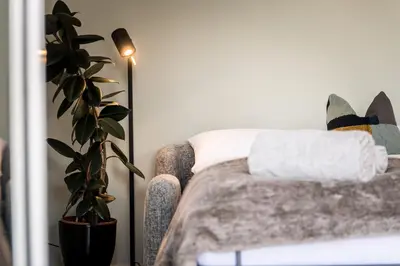 a bedroom with a bed with a plant and a lamp at ANDERS City Loft in Brunico