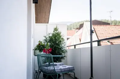 a balcony with a chair and a plant at ANDERS City Loft in Brunico