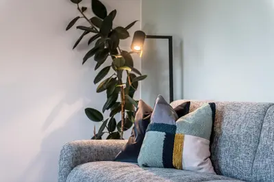 a couch with two pillows on it with a plant at ANDERS City Loft in Brunico