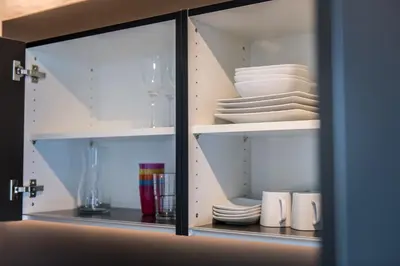 a cupboard with plates and dishes in it at ANDERS City Loft in Brunico