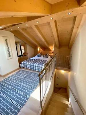 a attic bedroom with a bed and a staircase at Villa Zubiana in Cortina dʼAmpezzo