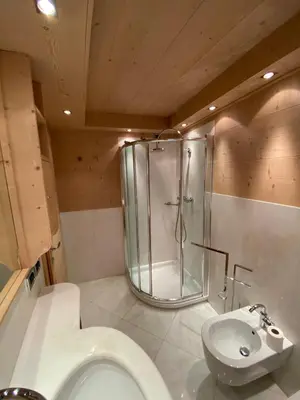 a bathroom with a shower and a toilet and a sink at Villa Zubiana in Cortina dʼAmpezzo