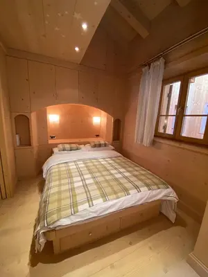 a bedroom with a large bed in a cabin at Villa Zubiana in Cortina dʼAmpezzo