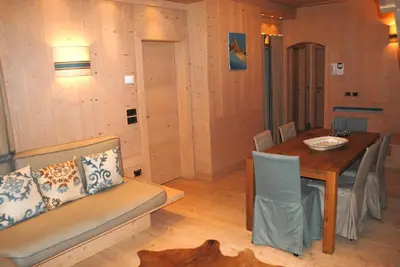a living room with a table and a couch and a dining room at Villa Zubiana in Cortina dʼAmpezzo