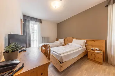 a bedroom with a bed and a desk with a computer at WHITE MOSS GARNì in Transacqua