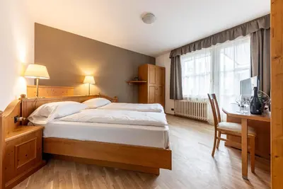 a bedroom with a bed and a desk and a window at WHITE MOSS GARNì in Transacqua