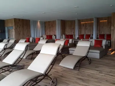 a waiting room with white chairs and red chairs at Hotel Rosslaufhof in Castelrotto