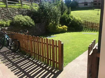 a bike parked next to a wooden fence at Romys Apartment in Selva di Val Gardena
