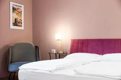 a bedroom with a bed and a purple headboard and a chair at Stay COOPER l Laurenz in Bolzano