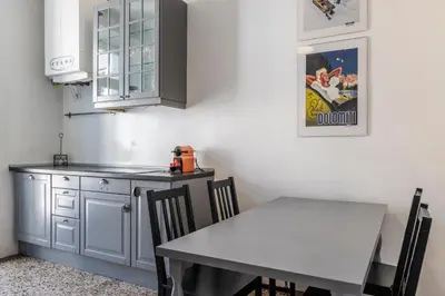 a kitchen with a white table and a table and a counter at Stay COOPER l Laurenz in Bolzano