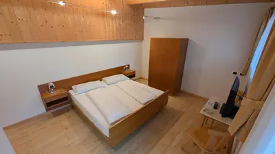 a bedroom with a bed with white pillows and a window at Garni Diamant in Colfosco