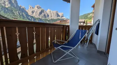a balcony with rocking chairs and a view of the mountains at Garni Diamant in Colfosco