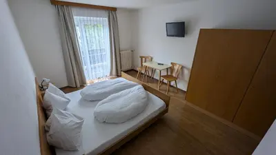 a bedroom with a bed with white pillows on it at Garni Diamant in Colfosco