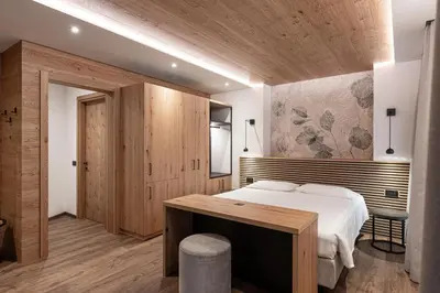 a bedroom with a large bed and a wooden ceiling at Le Fronde - Naturally Smart in Cles