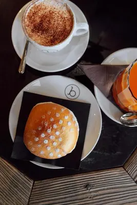 a cup of coffee and a bagel on a table at Le Fronde - Naturally Smart in Cles