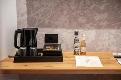 a coffee maker on a table with a bottle of wine at Le Fronde - Naturally Smart in Cles
