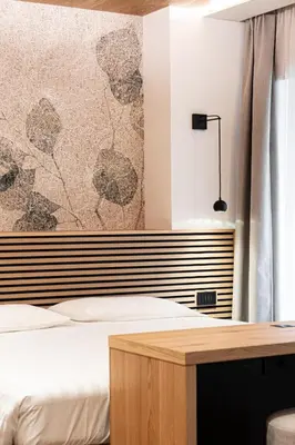 a bedroom with a bed and a desk with a curtain at Le Fronde - Naturally Smart in Cles