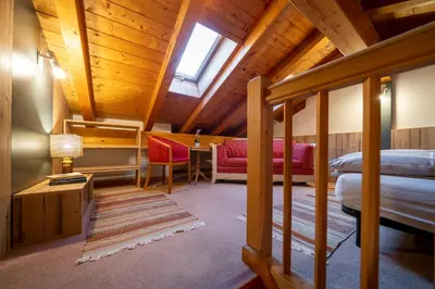 a room with two beds and a desk in a cabin at Ciasa Buro - Resh in Moena