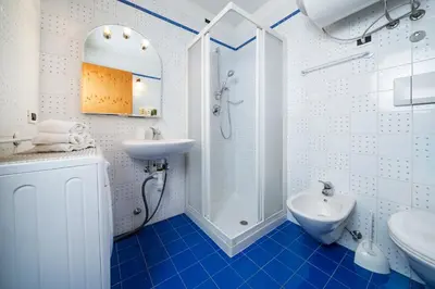 a blue and white bathroom with a sink and a shower at Ciasa Buro - Resh in Moena