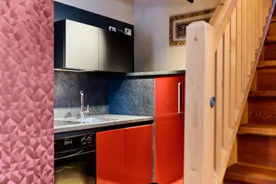 a kitchen with red cabinets and a sink at Ciasa Buro - Resh in Moena