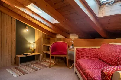 a living room with a red couch and a desk at Ciasa Buro - Resh in Moena